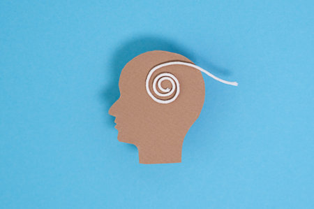 A head with a string wrapped around it. The head is brown and the string is white. The head is cut...