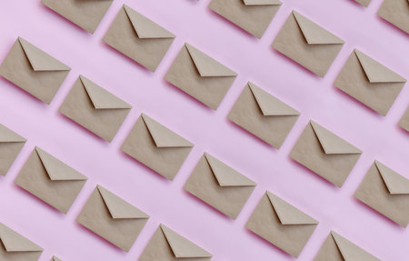 Kraft brown paper envelopes on pink background