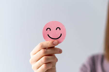 Concept Photo, Funny Emoji on Sticker in Young Woman's Handの写真素材