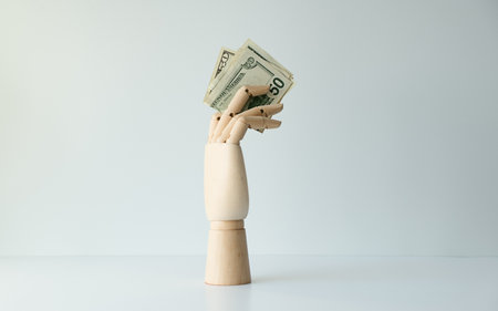 A hand holding a stack of fifty dollar bills.の写真素材