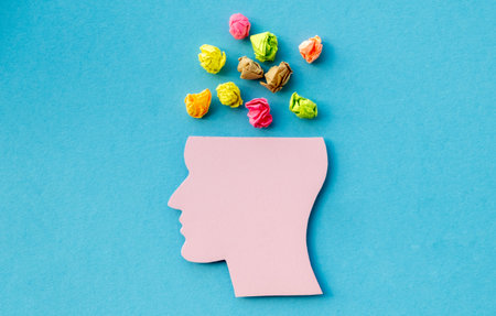 World mental health day concept. Paper human head symbol and crumpled colored papers on blue...