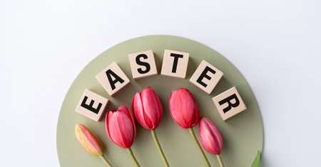 A group of red tulips are arranged in a circle with the word Easter written in black lettersの写真素材