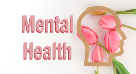 A pink flower with a head on it with the words mental health written below it. Concept of hope and positivity, as the flower represents growth and the head represents the mindの写真素材
