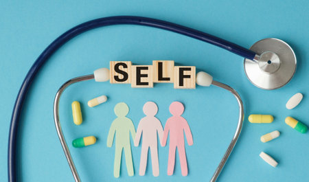 A stethoscope is on a blue background with the word "self" written in wooden blocks. Concept of self-care and the importance of taking care of one's healthの写真素材
