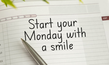 A pen is on a calendar with the words Start your Monday with a Smile written in the cornerの写真素材