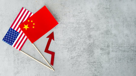 Two flags, one red and one white, are on a grey background. The flags are held up by sticksの写真素材