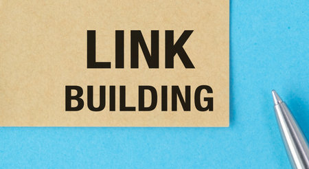 A pen is on top of a piece of paper that says Link Building. Concept of creating links between...