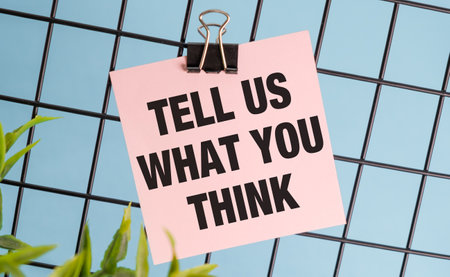 TELL US WHAT YOU THINK text on sticker on the blue background with flower