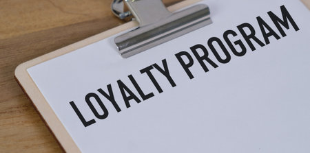A clipboard with the word loyalty written on it. The clipboard is on a wooden surface. The clipboard...