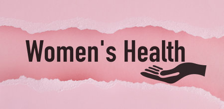A pink background with a hand holding a sign that says Women's Health. The pink background and the hand holding the sign give a sense of care and support for women's healthの写真素材