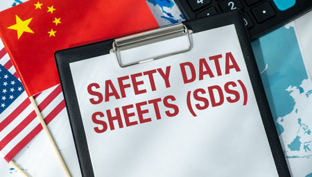 A safety data sheet is written on a clipboard. The clipboard is on a table with a red and white American flag and a calculatorの写真素材
