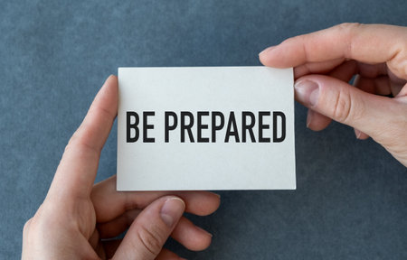 A hand holding a white card that says Be Prepared. Concept of readiness and preparedness for...