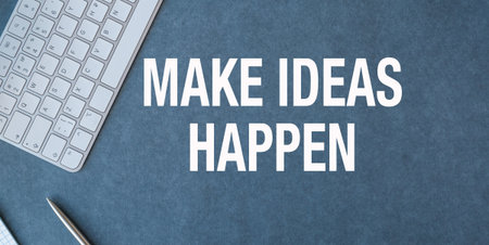 A keyboard and pen on a blue background with the words Make Ideas Happen. Concept of creativity and productivityの写真素材