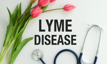 A stethoscope is on a table with a bouquet of flowers and the word Lyme Disease written below it