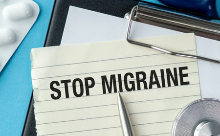 A piece of paper with the words Stop Migraine written on it. A pen is sitting on top of the paperの写真素材