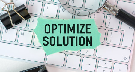 A green piece of paper with the word Optimize Solution written on it. It is sitting on top of a...