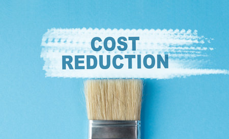 A paintbrush with the word Cost Reduction written on it. The brush is on a blue backgroundの写真素材