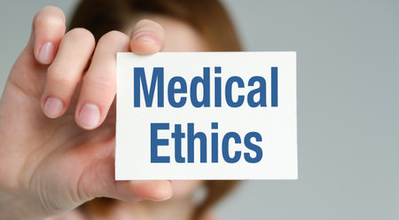 A person holding a card that says Medical Ethics. The card is blue and whiteの写真素材