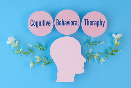 A head with the words cognitive behavioral therapy written around it. The head is surrounded by flowers. The flowers are green and whiteの写真素材