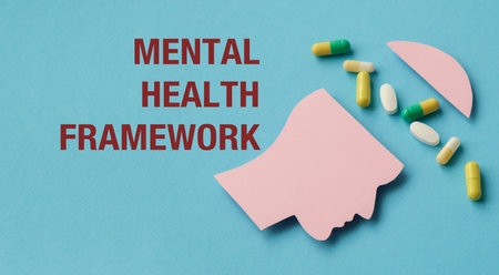 A pill bottle with a pink head on it. The head is cut in half. The pill bottle is on a blue background and text Mental Health Framework, Medical Conceptの写真素材