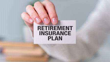 A person is holding a card that says Retirement Insurance Plan. The card is white and has black writingの写真素材