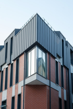 A building with a brick facade and a metal roof. The roof has a corner that is visibleの写真素材
