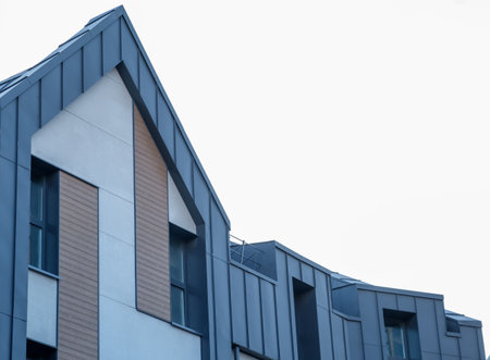 A large building with a blue roof and a white facade. The building has a lot of windowsの写真素材