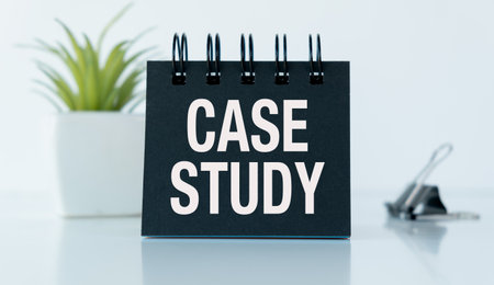 A black case study is placed on a white table. The case study is written in black and white, and it is important to note that the case study is a detailed analysis of a particular subject or situationの写真素材
