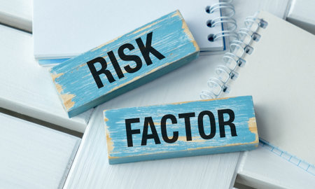 A blue and black sign that says Risk Factor. There is a spiral notebook next to the sign