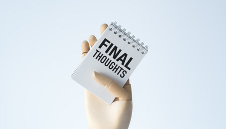 A person holding a spiral notebook with the words Final Thoughts written on it. The notebook is open...