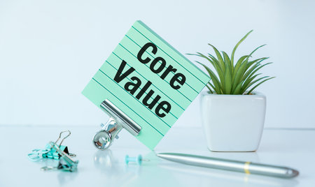 A green notepad with the word Core Value written on it. A pen is sitting on the notepad