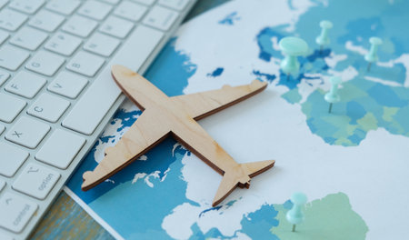 A wooden airplane is on top of a map of the world. The airplane is placed in the middle of the map,...