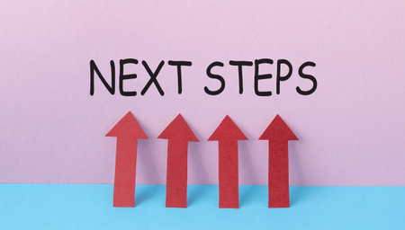Four red arrows pointing upwards, with the words Next Steps written below them. The concept of the image is to convey the idea of progress and moving forward, as the arrows represent upward movementの写真素材
