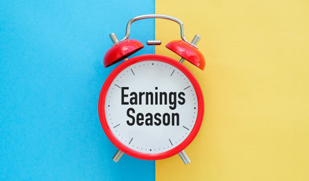 A red alarm clock with the words Earnings Season written on it. The clock is set to the time of