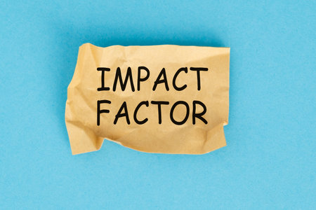 A piece of paper with the word Impact Factor written on it. The paper is crumpled and torn, giving...