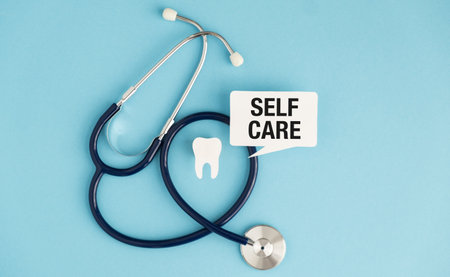 A stethoscope is on a blue background with a sign that says Self Care The stethoscope is surrounded by a tooth and a speech bubble that says "Self Care"の写真素材