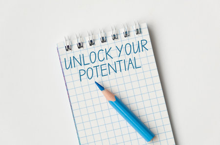A blue pencil is on a spiral bound notebook with the words Unlock Your Potential written in blue. The pencil is sharpened and ready to be usedの写真素材