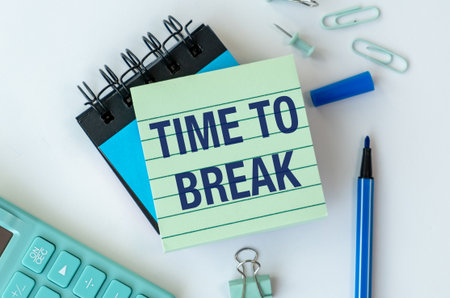 A green notebook with the word Time to Break written on it. A blue pen is sitting on top of the notebookの写真素材