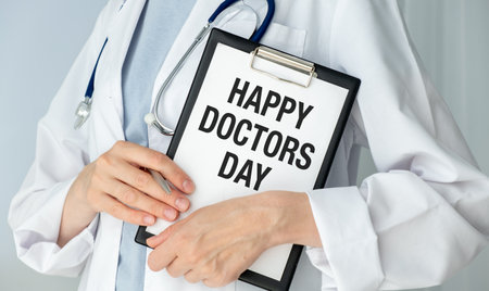A doctor holding a clipboard with the word Happy Doctors Day written on it.