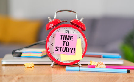 Red alarm clock with Time to Study text on wooden table, Education concept with books