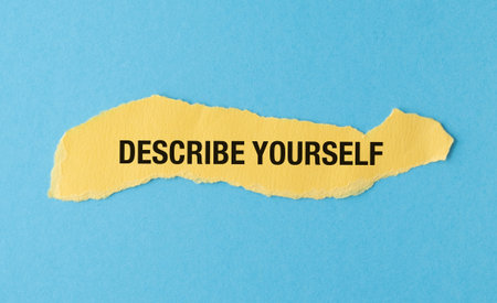 A torn piece of paper with the words Describe Yourself written on it. The paper is yellow and has a blue backgroundの写真素材