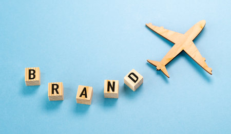 A wooden airplane is flying over a blue background with the letters