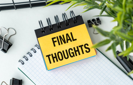 A notebook with a piece of paper that says Final Thoughts on it. The notebook is on a table with a...