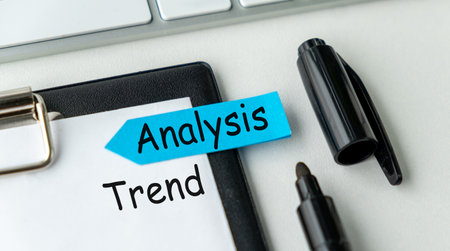 A blue sticky note with the word Analysis Trend written on it is on top of a clipboard. A black pen is next to the clipboardの写真素材