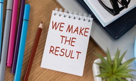 We Make The Result text on notepad with colored pencils on office desk, business conceptの写真素材
