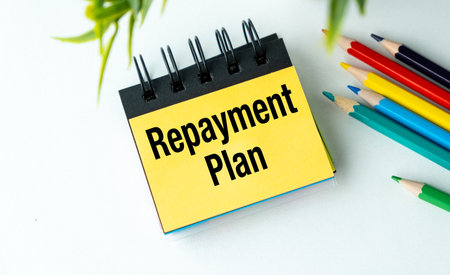 Repayment Plan text on notepad with colored pencils on office desk, Business Conceptの写真素材