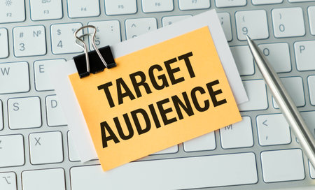 A yellow note with the word written on it is clipped to a keyboard. The note is placed on the keyboard in front of a penの写真素材