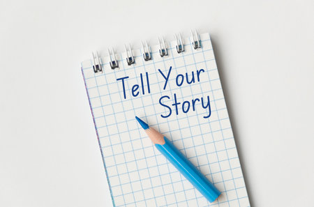 Tell Your Story text on open page notebook and blue pen on white backgroundの写真素材