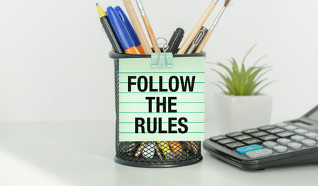 A pen holder with a sign that says Follow the Rules The pen holder is filled with pens and pencilsの写真素材