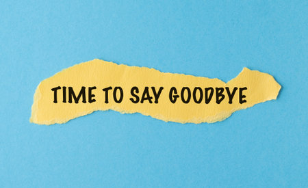 A torn piece of paper with the words Time to Say Goodbye written on it. The paper is yellow and has a blue backgroundの写真素材